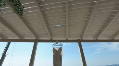 Closeup şenlikli gelinlik terasta rüzgar ile arka plan mavi denizde billowing