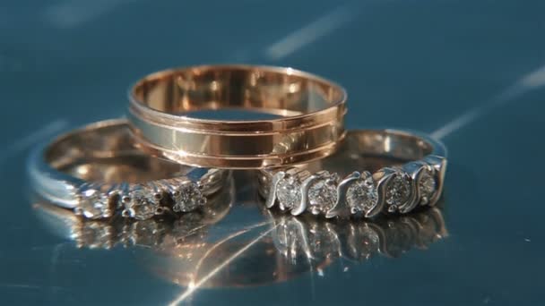 Closeup γαμήλια δαχτυλίδια με διαμάντια σε γυάλινο τραπέζι — Αρχείο Βίντεο