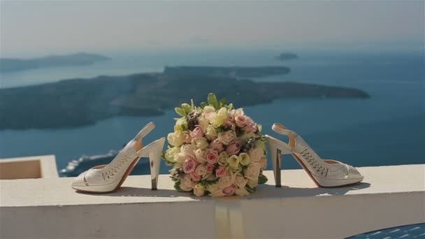 Stilvolle weiße Hochzeitsschuhe und Rosenstrauß im Freien mit Stadt im Hintergrund — Stockvideo