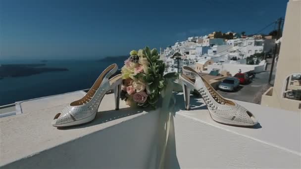 Stylové bílé svatební boty a růže kytice venku s městem v pozadí — Stock video