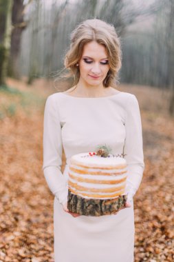 Çekici sarışın gelin düğün pastası sonbahar ormandaki ile