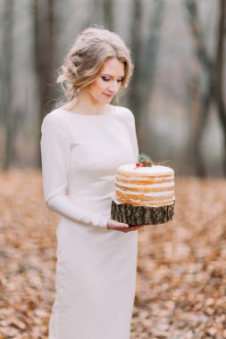 Çekici sarışın gelin düğün pastası sonbahar ormandaki ile