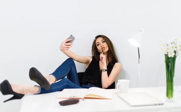Young pretty business woman at her workplace making a selfie — Stock Photo, Image