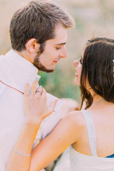 Retrato al aire libre de una hermosa pareja sentada en el campo de trigo. Vista trasera — Foto de Stock