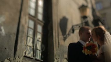 Güzel gelin ve damat usulca eski şehir merkezinde sarılma