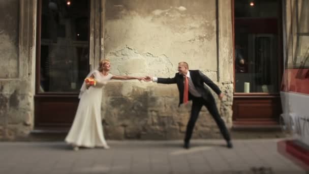 Alegre pareja de boda divirtiéndose en las calles de la vieja ciudad de Lviv — Vídeos de Stock