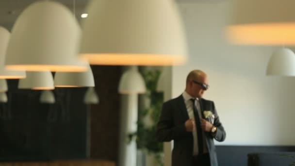 Fiducioso uomo d'affari in occhiali da sole che balla al ristorante e celebra il suo accordo vincente — Video Stock