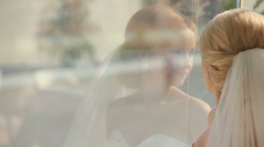 Genç güzel gelin pencereden içeri onun damat üzerinde seyir