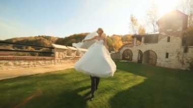 Mutlu damat ellerde büyüleyici gelini taşır. Genç yeni evliler Ortaçağ Kalesi birlikte eğleniyor