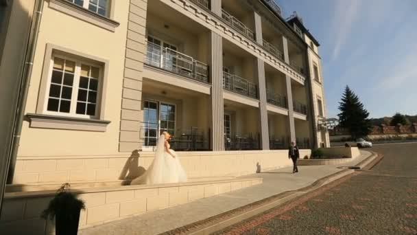 Verheugd huwelijksfeest paar vergadering op het hotelgebouw op hun trouwdag — Stockvideo