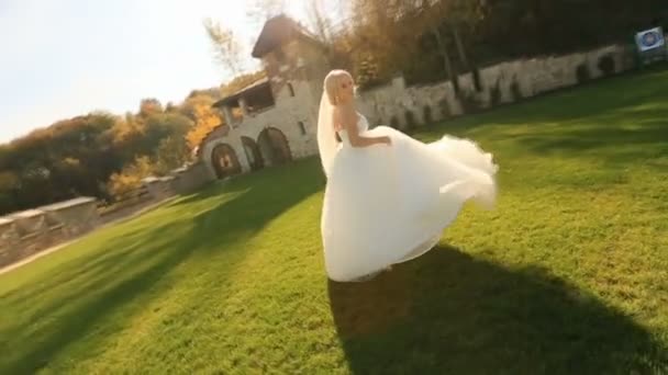 Динамічне відео красивої блондинки в білій сукні на середньовічному дворі замку — стокове відео