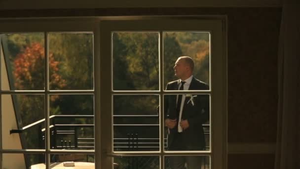 Eleganter Bräutigam posiert auf dem Balkon luxuriöser Hotelzimmer-Appartements — Stockvideo
