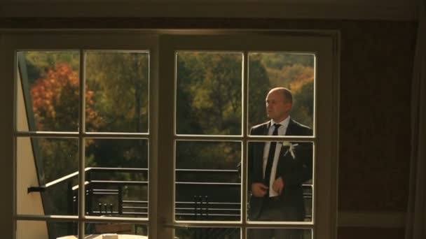 高級ホテルの部屋のバルコニーにポーズ ハンサムな新郎 — ストック動画