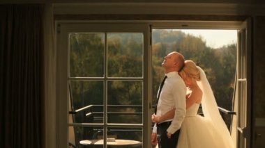 Güzel seksi gelin ve balkonda yakışıklı damat kucaklayan ihale. Balayı konsepti