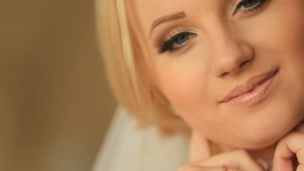 Крупным планом улыбается лицо великолепной блондинки с элегантным макияжем и блестящие бриллиантовые серьги — стоковое видео