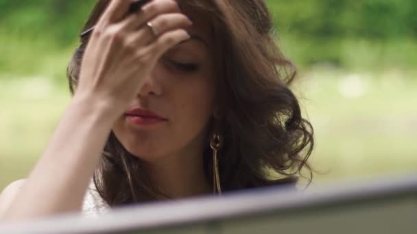 Outdoor portrait of a happy beautiful female artist with a pencil in hands on the foreground — Stock Video