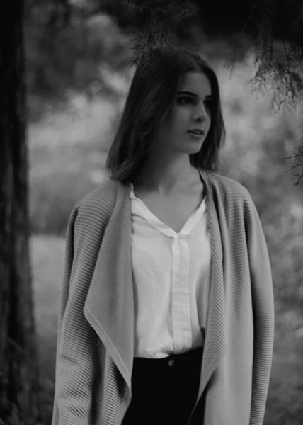 Portret van een peinzende jonge vrouw weg te kijken op de achtergrond voorjaar park, zwart-wit — Stockfoto