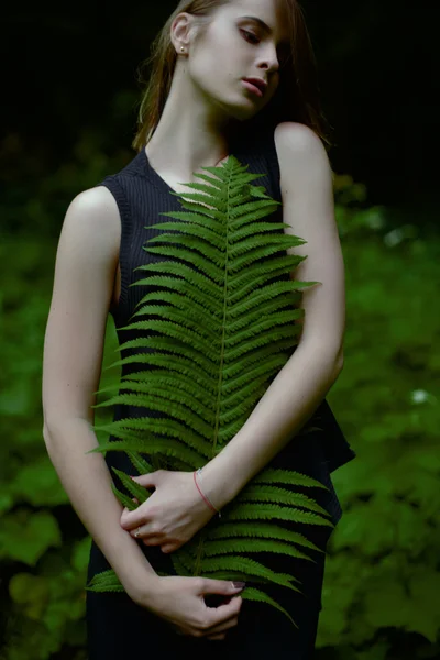 Amor concepto de la naturaleza. Mujer sostener tiernamente las hojas de helecho en el bosque profundo — Foto de Stock