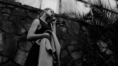 Sarışın genç kadın üstte, ceket elinde tutan, sera poz kot giyen siyah ve beyaz fotoğraf