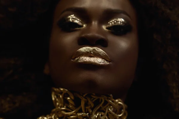 Grote close-up surrealistisch portret van majestueuze Afro-Amerikaanse vrouwelijke model met gouden glanzend make-up. Mode Vogue concept — Stockfoto