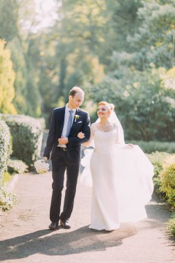 Mutlu genç Düğün çifti birlikte bahar parkta yürüyüş.