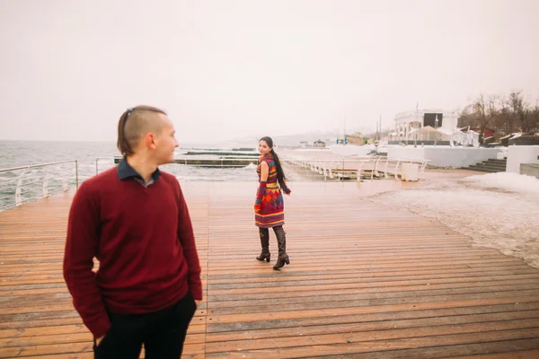 Ragazza con un ragazzo che cammina sul molo. Giorno di autunno piovoso — Foto Stock