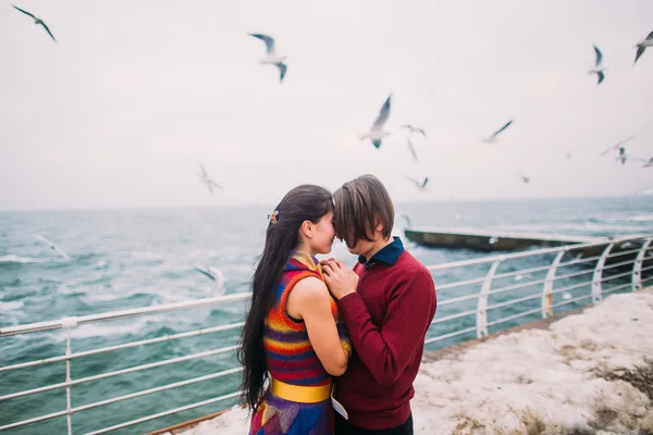 Lovers on the pier and seagulls at background. Romantic honeymoon — Stock Photo, Image