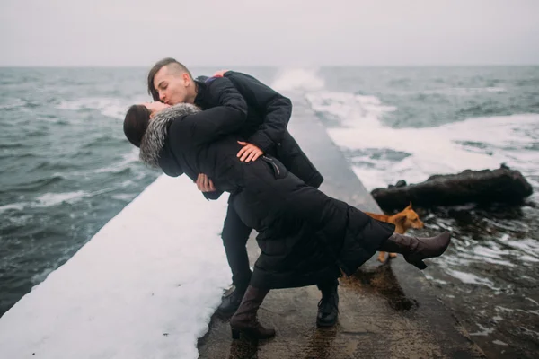 Городской стиль молодой счастливой пары, стоящей на пирсе у моря и страстно целующейся. Прекрасный медовый месяц — стоковое фото