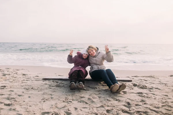 Mãe e filha feliz posando na praia de inverno. Bela foto de família — Fotografia de Stock