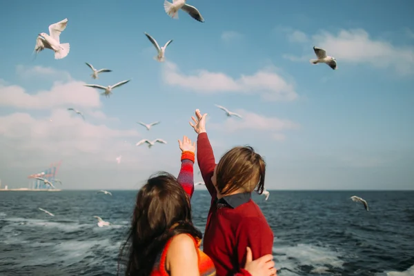 Retrato de pareja romántica brillante luciendo feliz y bailando. Hermoso mar azul calma con gaviotas voladoras en el fondo — Foto de Stock