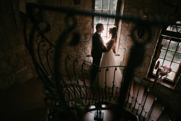 Jong getrouwd paar staande face-to-face bij de trappen en hand in hand — Stockfoto