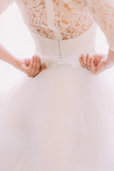 Элегантное стильное винтажное белое свадебное платье с орнаментами и бантами на спине невесты крупным планом — стоковое фото