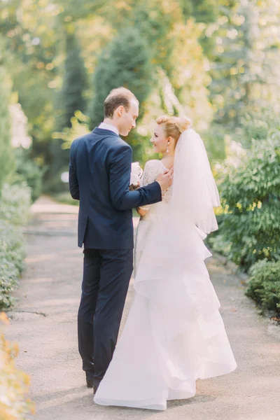 Novia y novio en el día de la boda caminando al aire libre en el fondo de la naturaleza de primavera —  Fotos de Stock