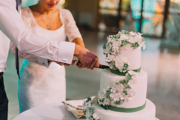 Mariée heureuse et marié coupant leur gâteau de mariage . — Photo