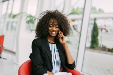 Afro saç modeli ile canlı güzel genç Afro-Amerikan bayan onu mobil arama dinlerken sohbet, zevk geniş ışınlama gülümseme