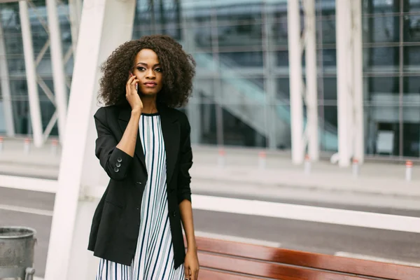 Empresária afro-americana séria usando telefone celular na rua — Fotografia de Stock