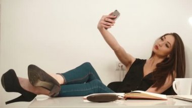 Oynak çekici genç iş kadını selfie telefon ve verme ördek ile yüz beyaz arka plan üzerinde alarak.
