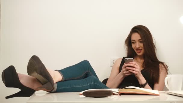 Joven seductora hermosa mujer de negocios juega por teléfono en la oficina — Vídeos de Stock