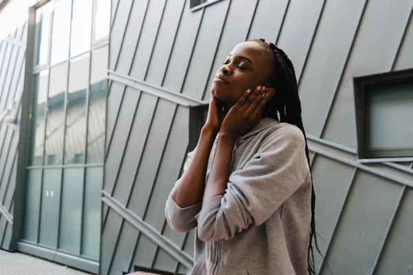 Jovem afro-americana desfrutando de música com fones de ouvido e olhos fechados — Fotografia de Stock