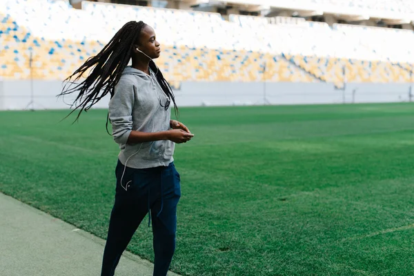 Vonzó fiatal afroamerikai nő a szürke sportruházat jogging a stadionban — Stock Fotó