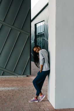 Spor giyimli genç kızın kulaklıklarıyla müzik dinlemesi rahatlatıcı yan görünümü