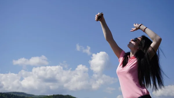 Гламурна дівчина в горах робить селфі на фоні блакитного неба — стокове фото