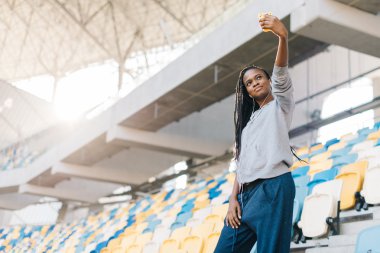 Güzel kadın afro-amerikan kız büyük güzel modern stadyumda banklarda oturan selfie yapma