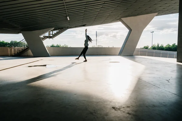 Concepto de deporte, danza y cultura urbana: hermosa bailarina saltando en el edificio — Foto de Stock