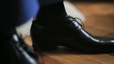 Mavili adam uygun resmi olay için hazırlanıyor uygulamakla siyah deri ayakkabı