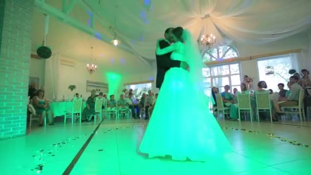 Mooie gevoelige bruid en knappe bruidegom eerste dans dansen op het bruiloftsfeest in hal met gekleurde lichten. 31.08. 2015, Lviv, Oekraïne — Stockvideo