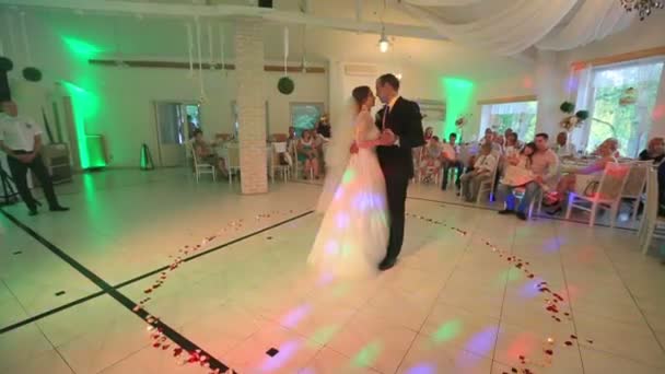 Mooie gevoelige bruid en knappe bruidegom dansen op het bruiloftsfeest in hal met gekleurde lichten. 31.08. 2015, Lviv, Oekraïne — Stockvideo