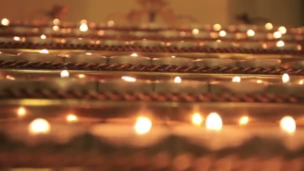 Close-up de velas votivas de oração cristã no rack de velas — Vídeo de Stock