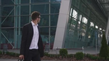 Çekici sakallı işadamı bardaklarda havaalanında ücretsiz taksi arıyorum. Cam Havaalanı duvar arka plan