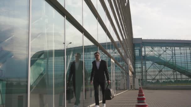 Elegante hombre de negocios barbudo ajusta su chaqueta antes de viajar de trabajo — Vídeos de Stock